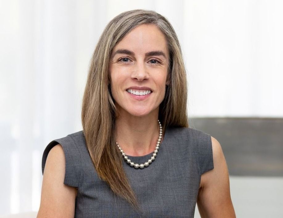 Woman in stylish lingerie poses near a wall.