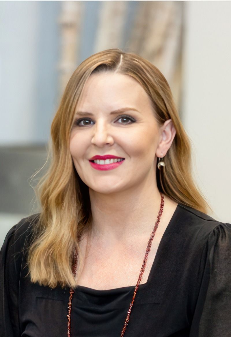 Smiling woman with long hair and earrings.