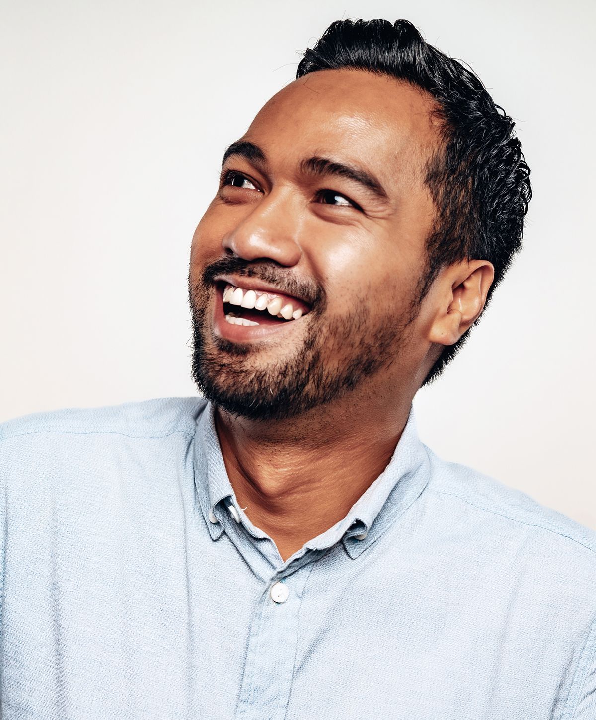 Man smiling against a light background.