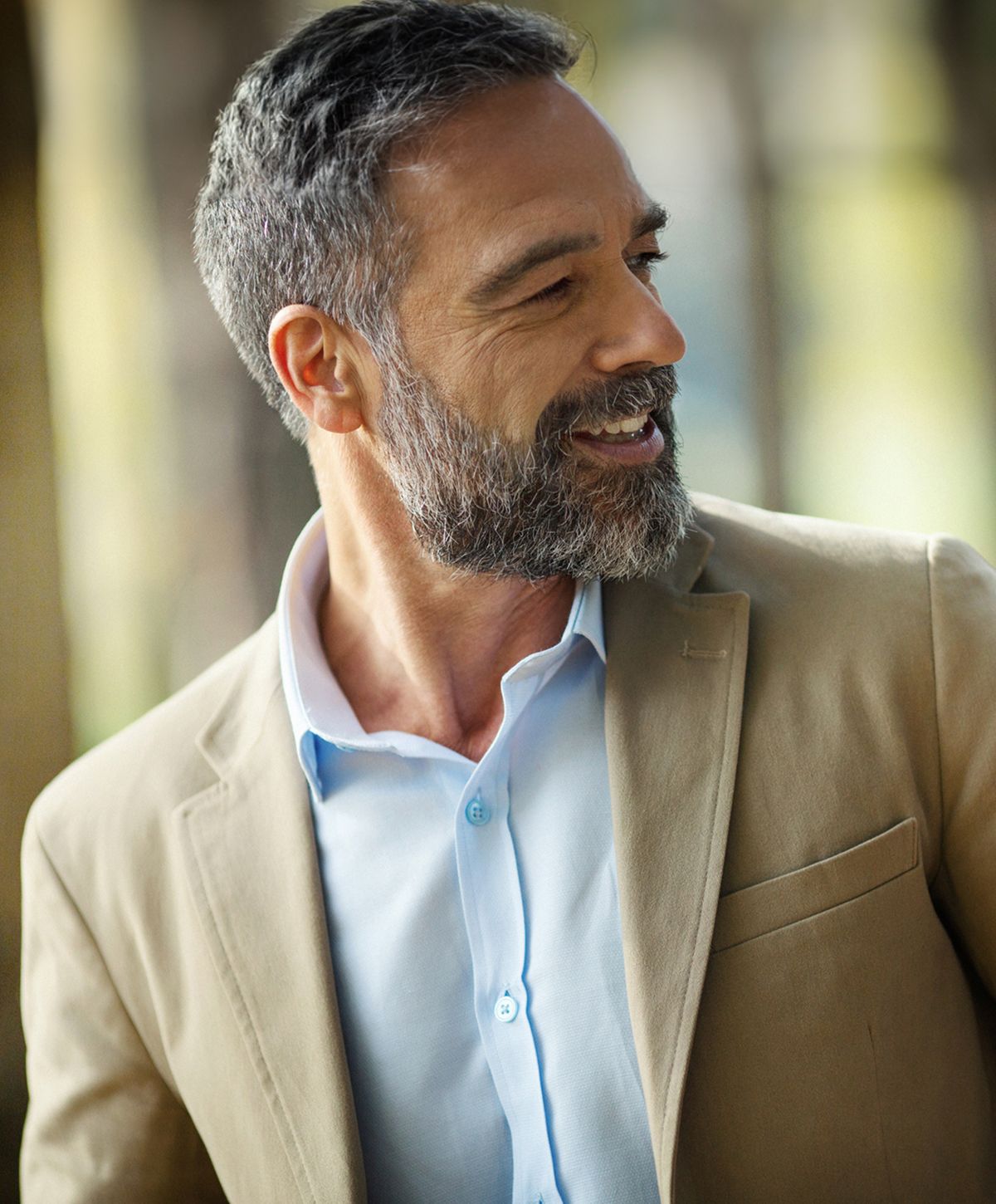 Smiling man in blazer with a light shirt.