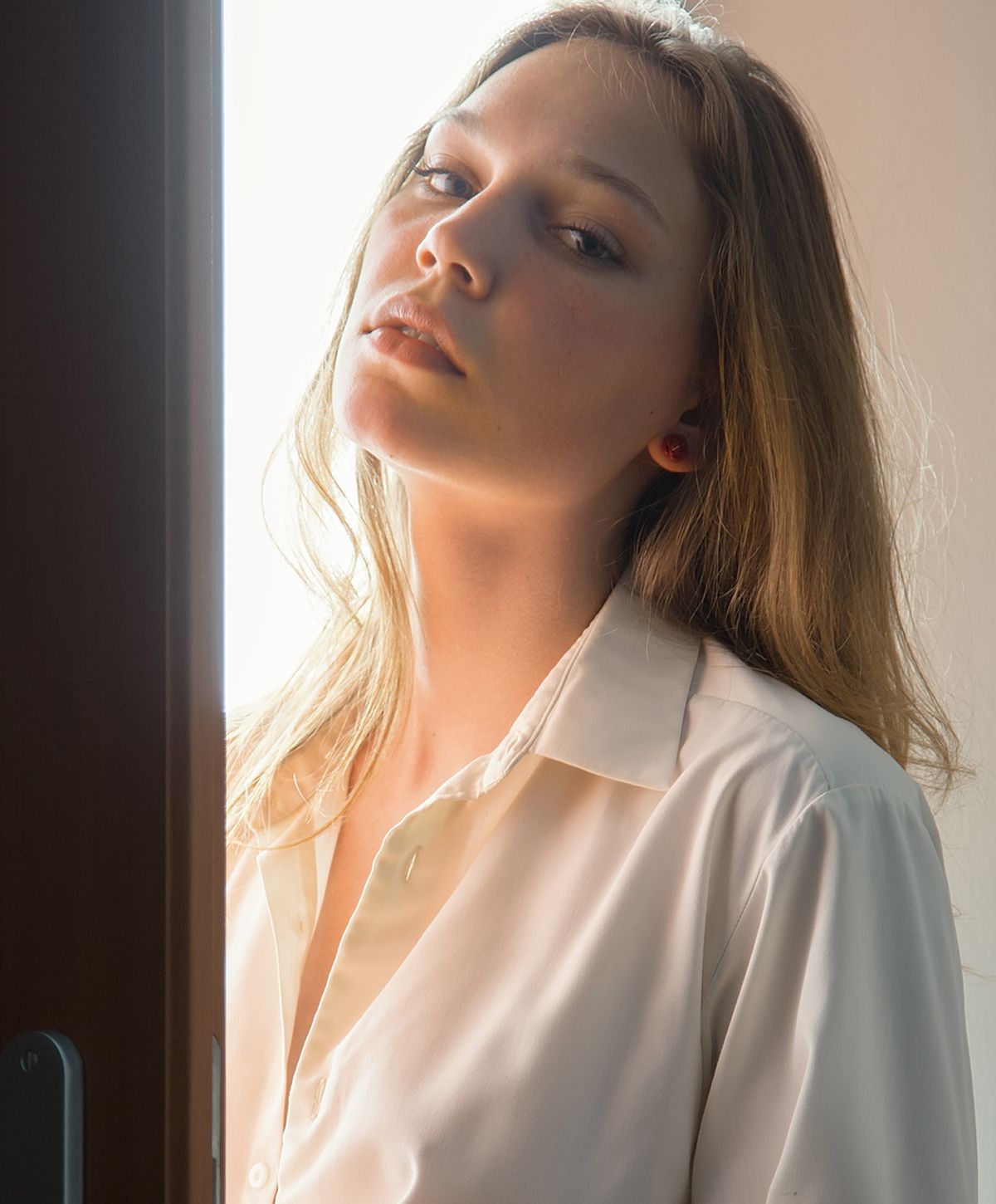 Young woman posing near a window.