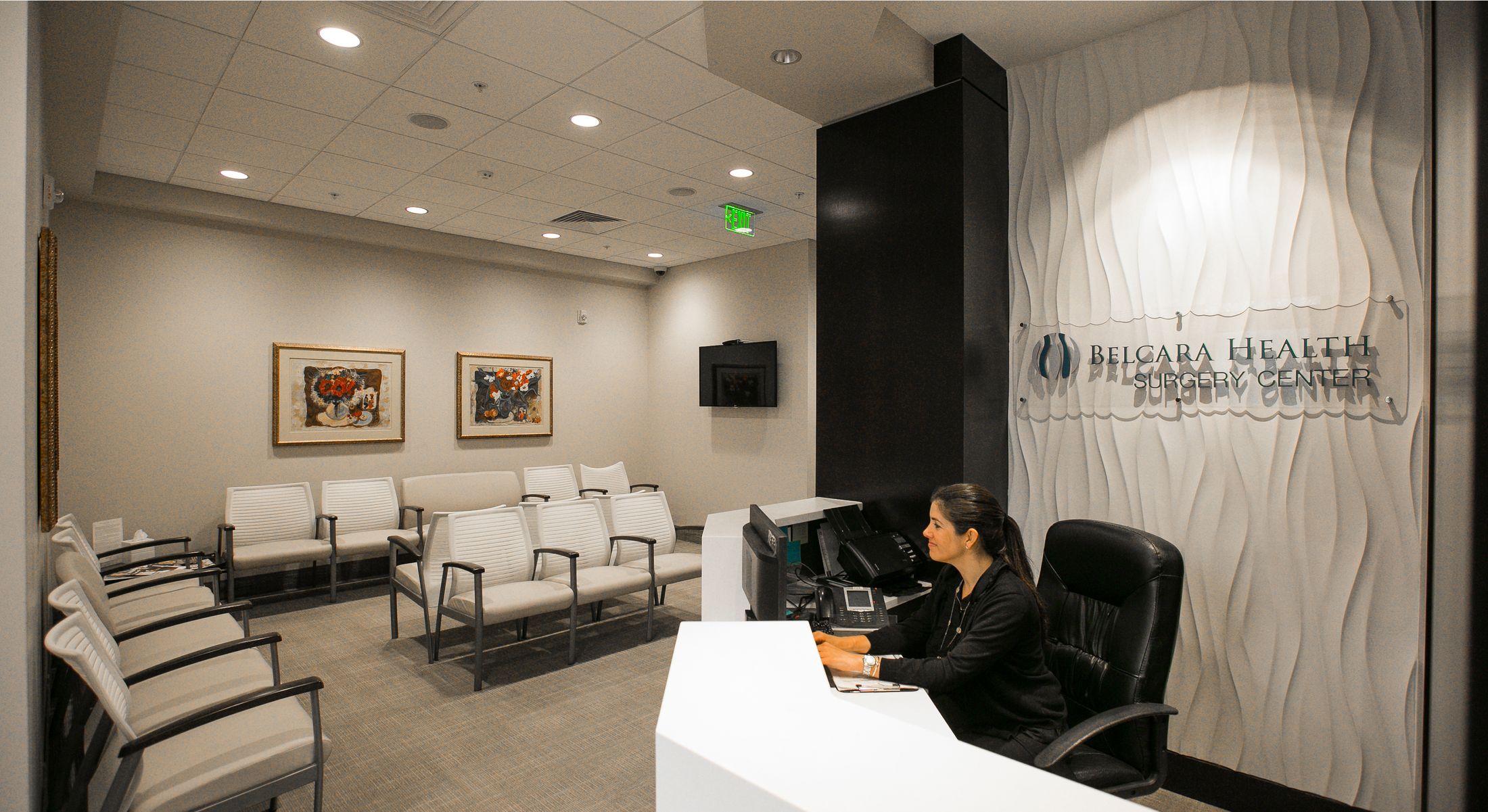 Modern healthcare reception area with desk and decor.