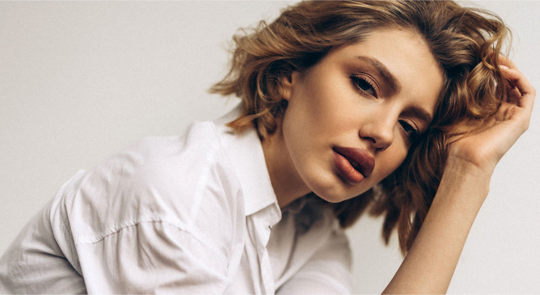 Woman with tousled hair and soft expression.