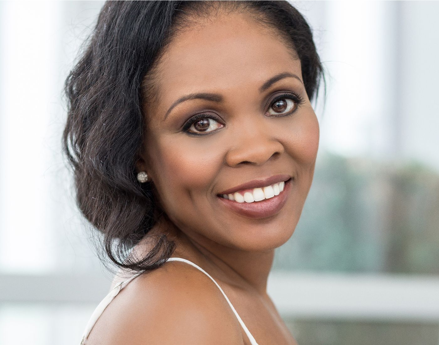 Smiling woman with beautiful hair and makeup.