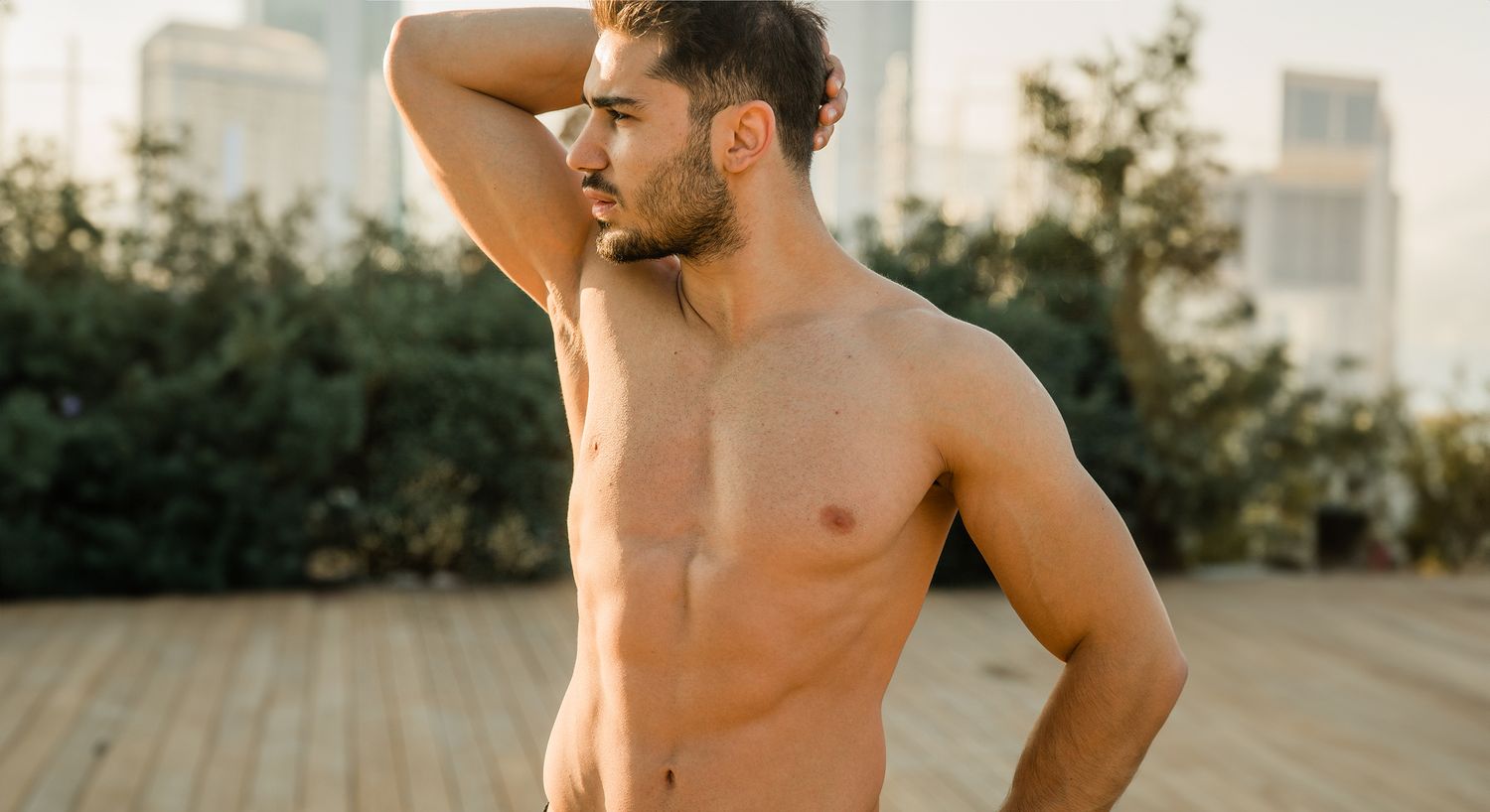 Man posing outdoors, enjoying sunlight.