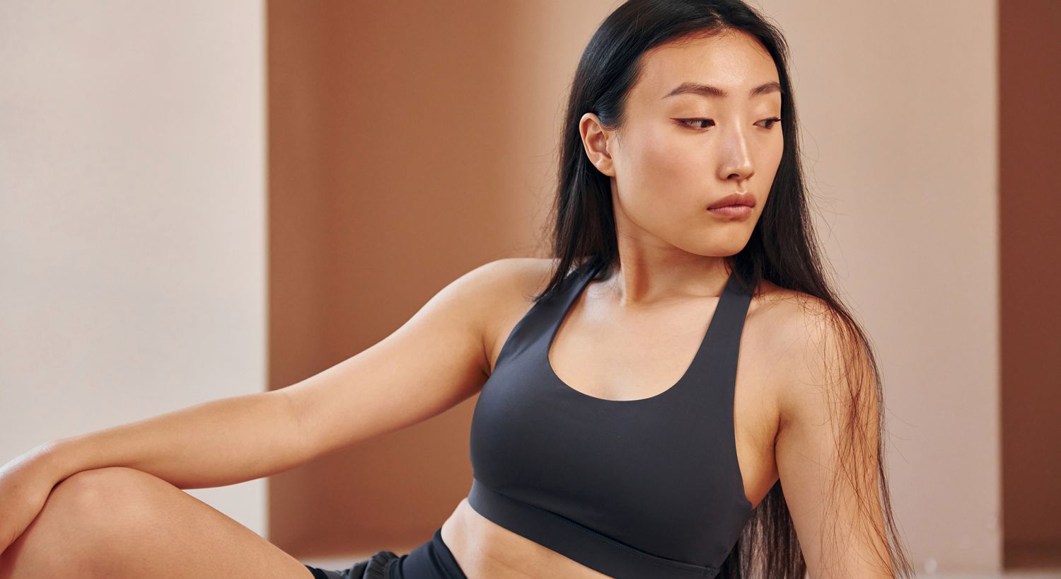 Young woman in activewear, posing thoughtfully.